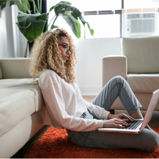 A woman sits in a living room on her laptop